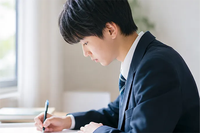机に向かって学習する生徒