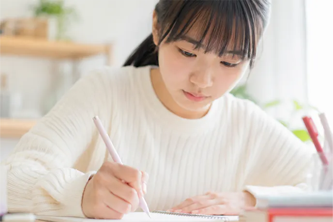 ノートに書き込みながら学習する生徒
