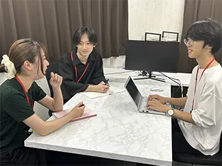 テーブルを囲んで学習内容を確認する講師と生徒